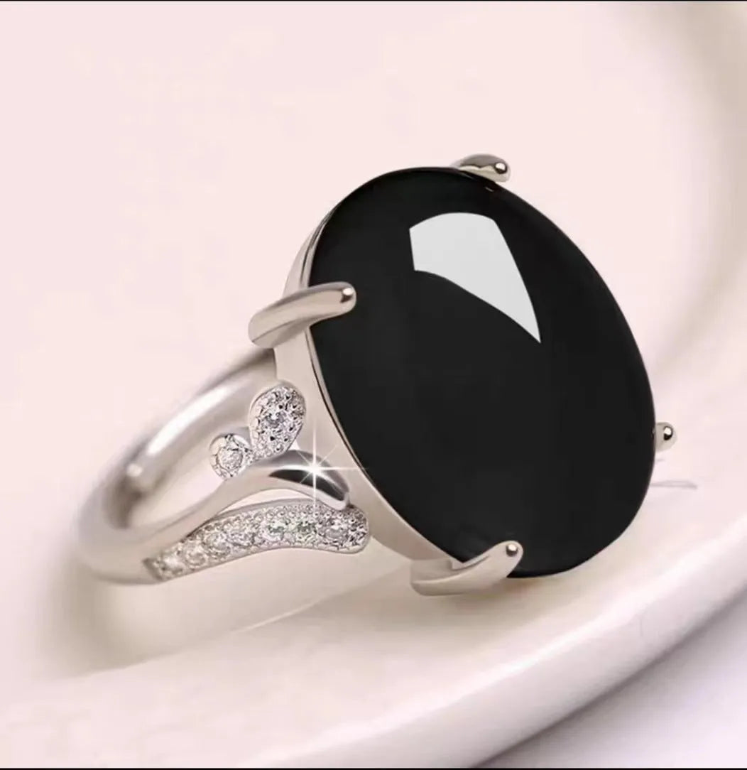 Geometric ethnic style adjustable alloy ring in one of five colours on a plain background.