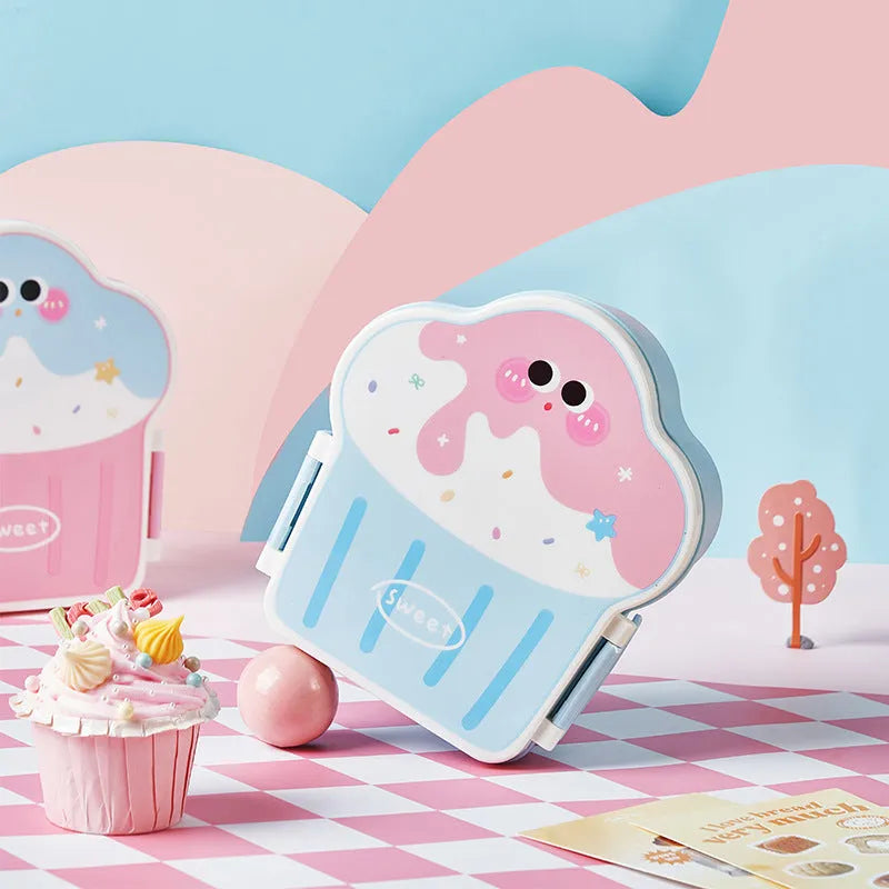 Pink and blue creative ice cream shaped plastic lunch box with compartments, shown with matching spoon and fork.