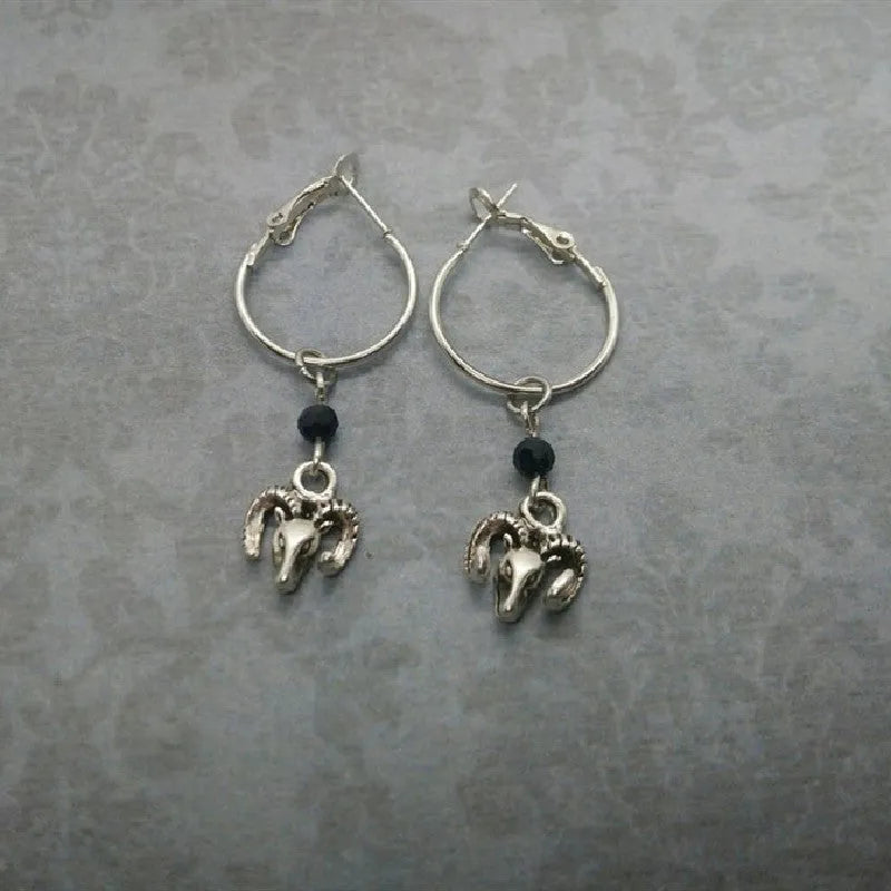 Silver coloured round alloy earrings featuring an engraved Tibetan antelope design.