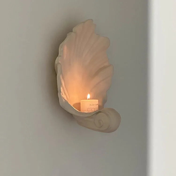 Close-up of a white resin decorative ornament with a detailed seashell design for fruit plates and table displays.