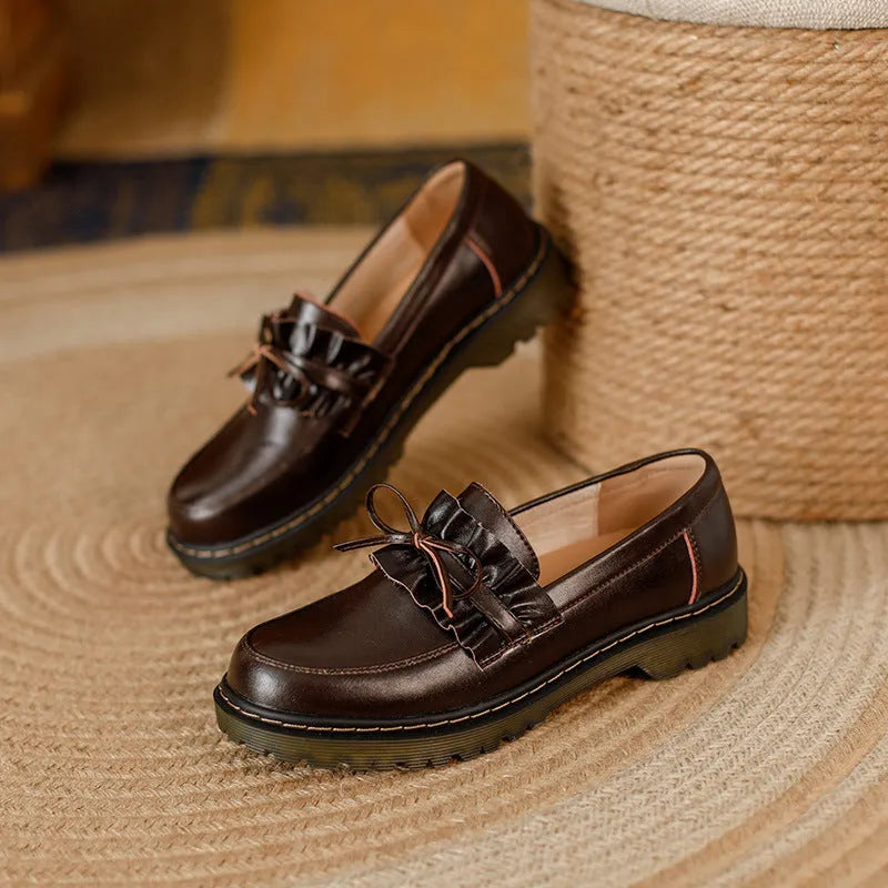 Women's black leather shoes with round toe, chunky flat heel, and low-top design on a white background.