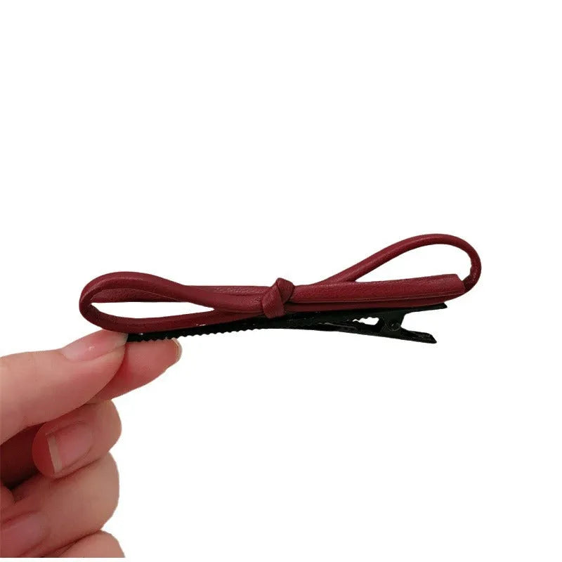 Wine red leather bow hair barrette showing bow design and clip mechanism