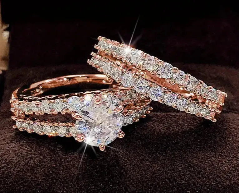 Two geometric women's rings with fully jewelled bands and round cut accents, shown in gold, rose gold, and silver colour options.