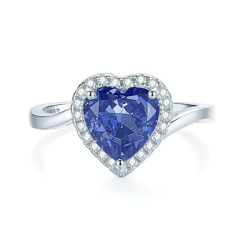 Heart shaped Tanzanite purple zircon ring in sterling silver on a grey background.