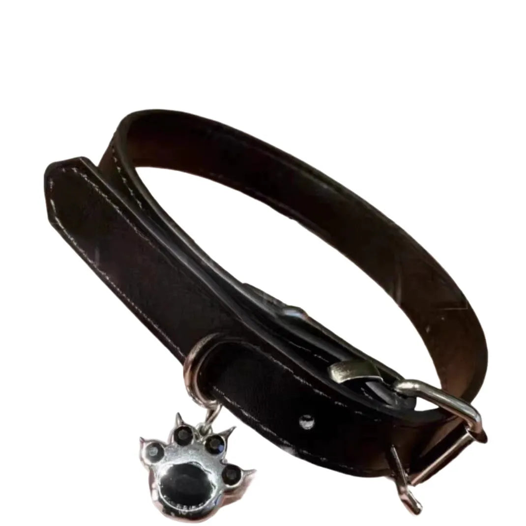 Black adjustable dog collar with small bell charm shown in leather, bone, and cat's paw designs.