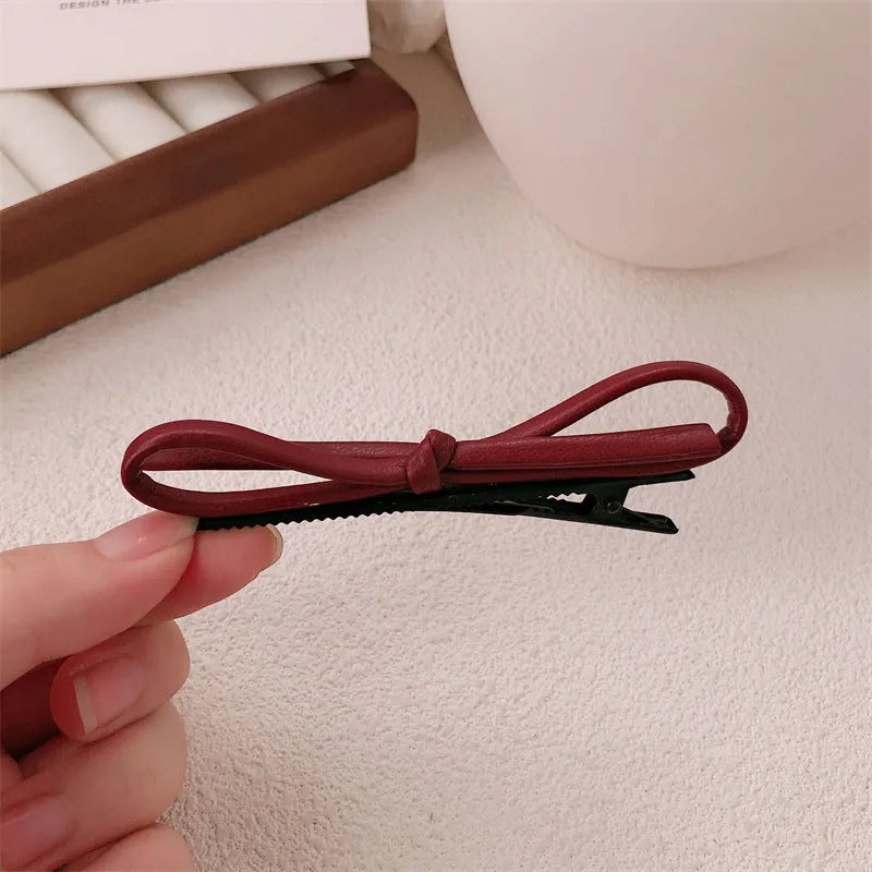 Wine red leather bow hair barrette showing bow design and clip mechanism
