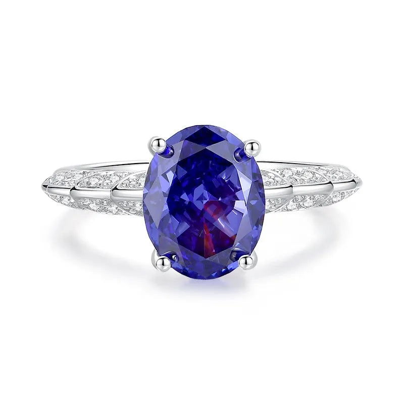 Heart shaped Tanzanite purple zircon ring in sterling silver on a grey background.