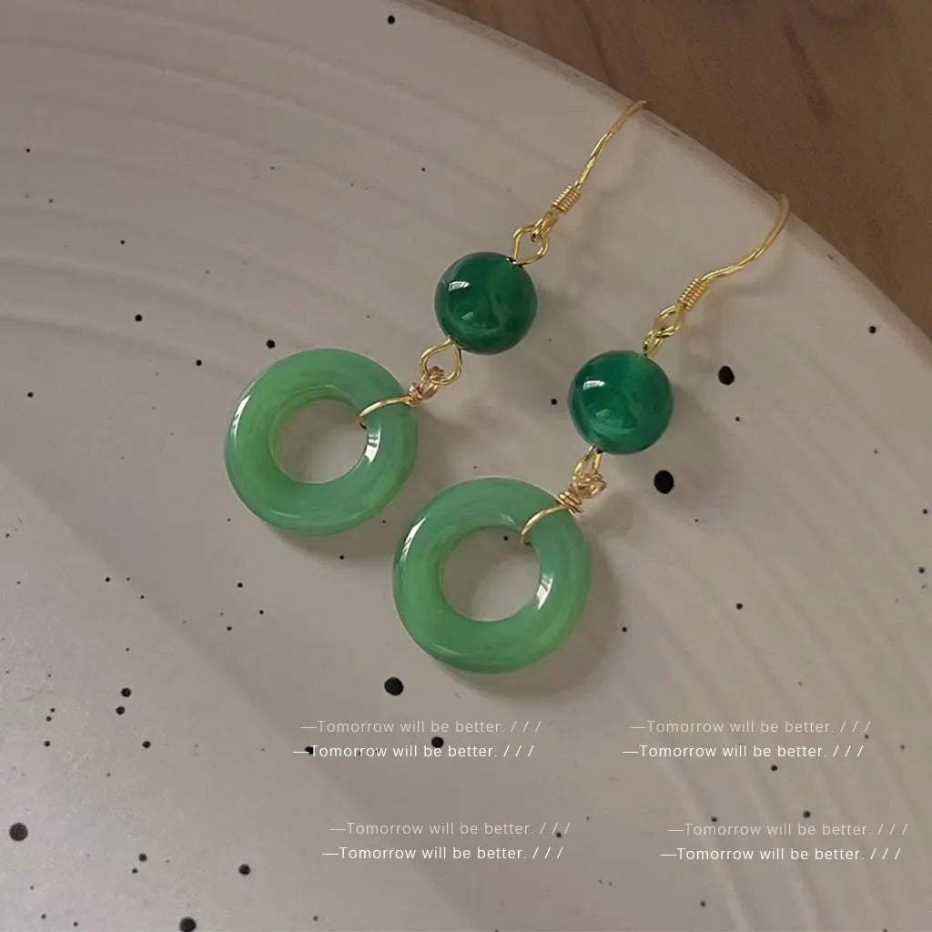 A pair of green geometric peace buckle earrings with a Chinese jade design, made from zinc alloy.