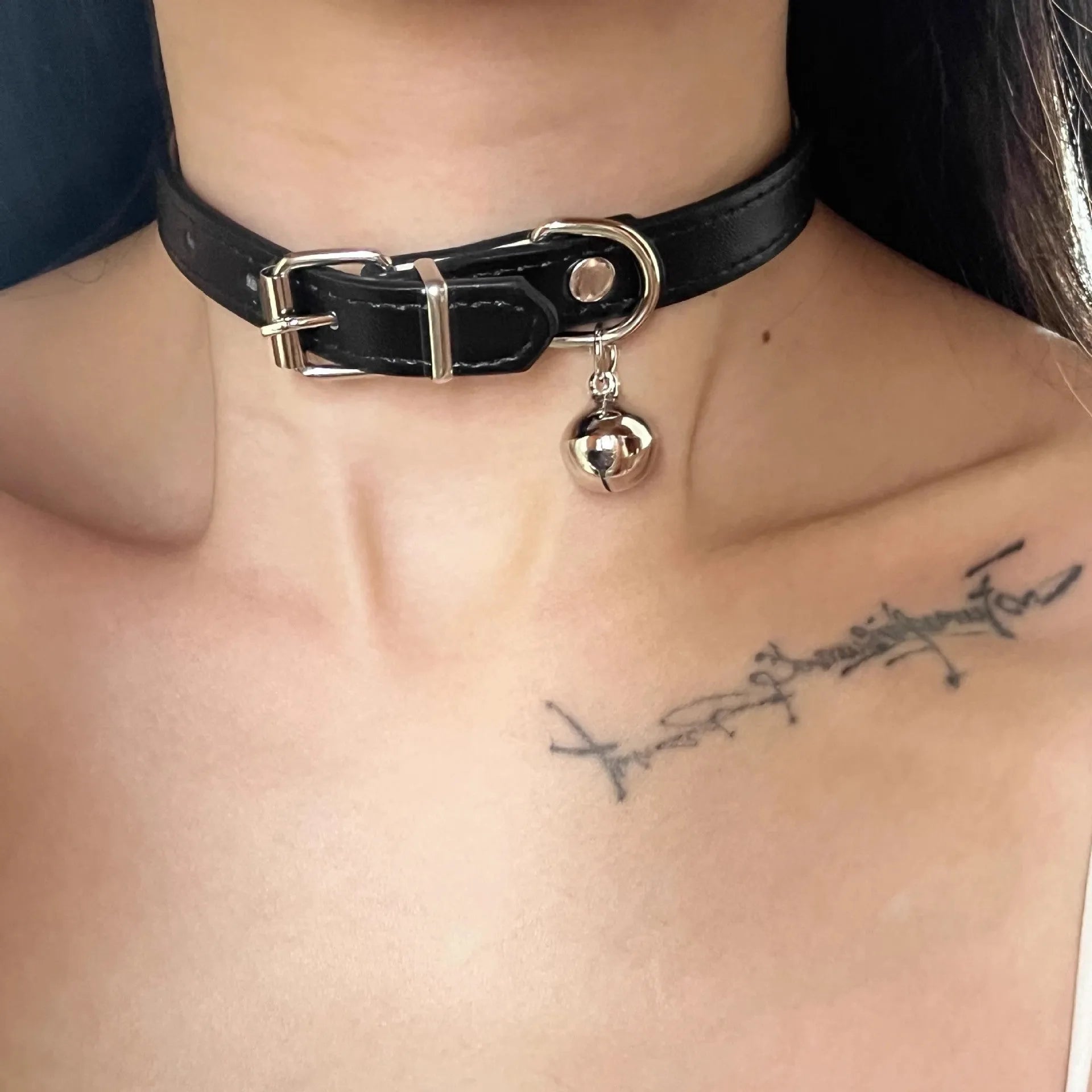 Black adjustable dog collar with small bell charm shown in leather, bone, and cat's paw designs.