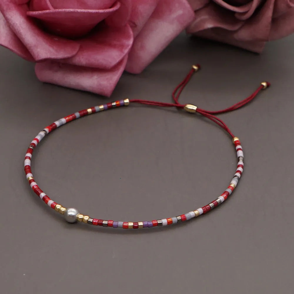 Handmade bohemian bracelet with colourful geometric glass beads on a female wrist.