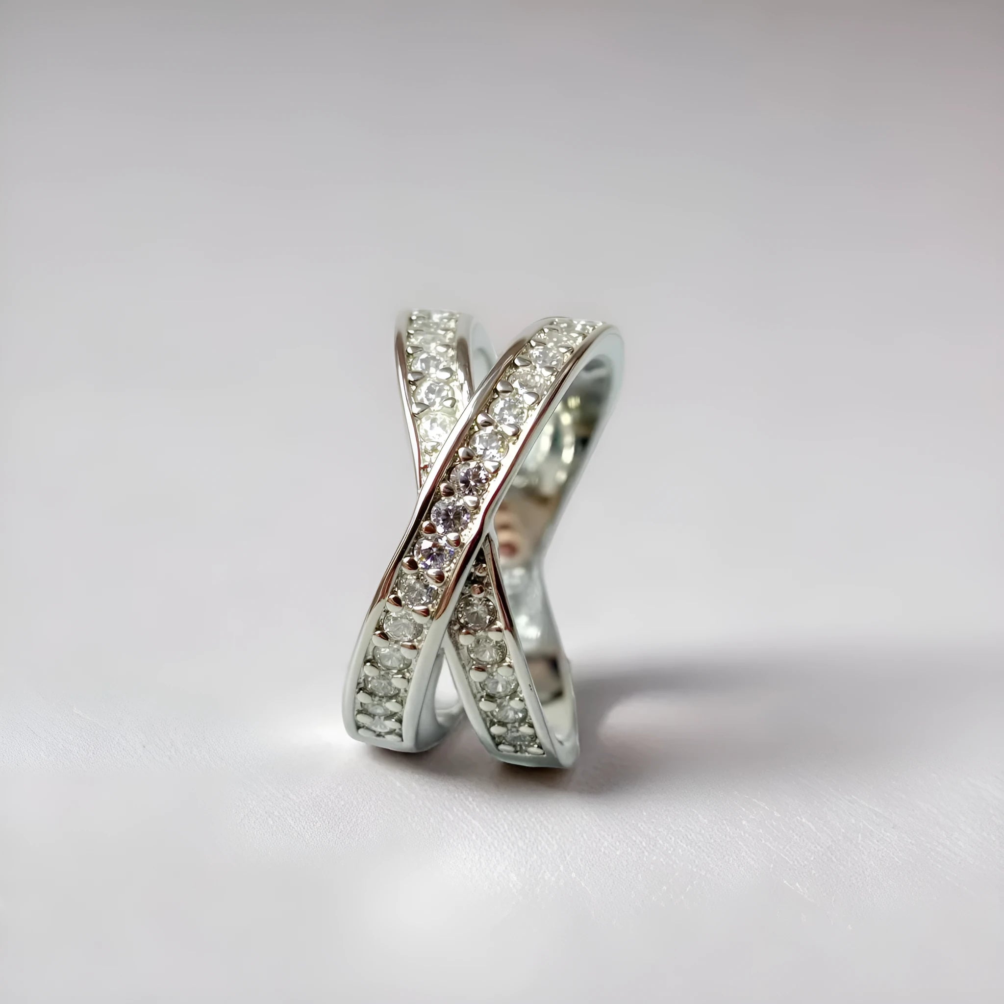 Electroplated copper cross ring with micro-inlaid zircon stones in silver finish