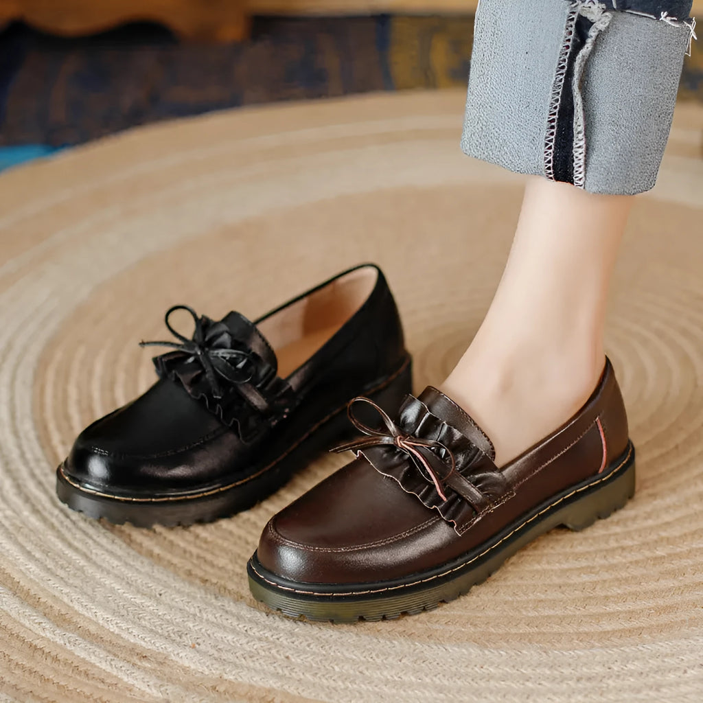 Women's black leather shoes with round toe, chunky flat heel, and low-top design on a white background.