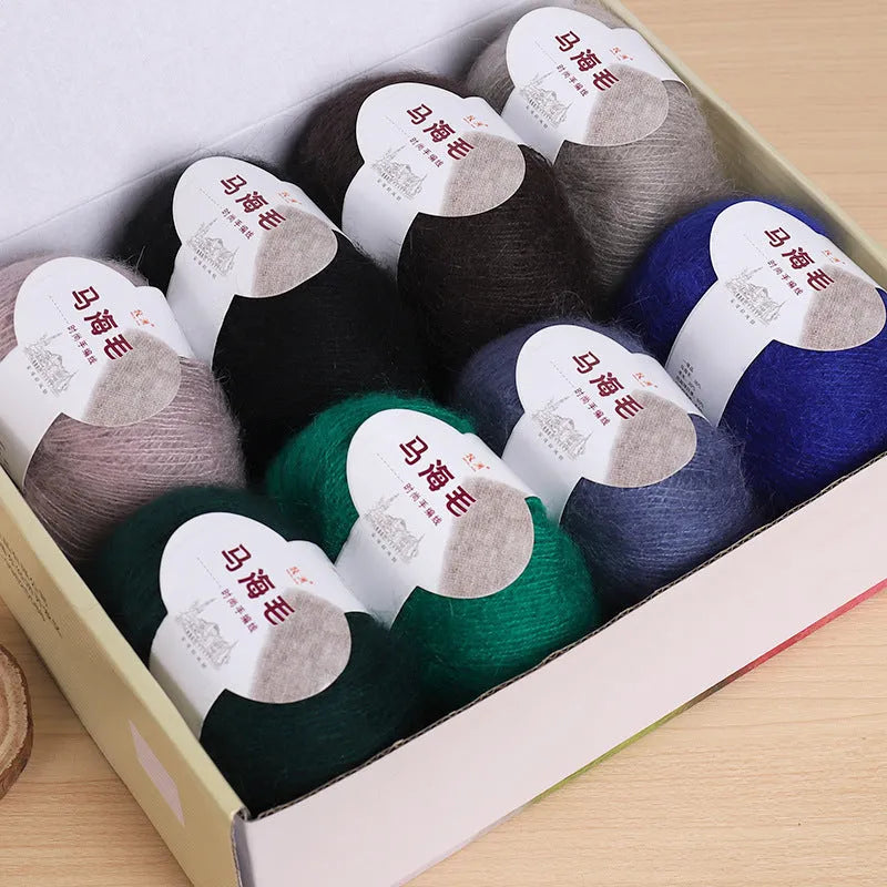 DIY mohair scarf weaving kit showing one wool ball and a selection of 34 colour options including white, pink, blue and green.