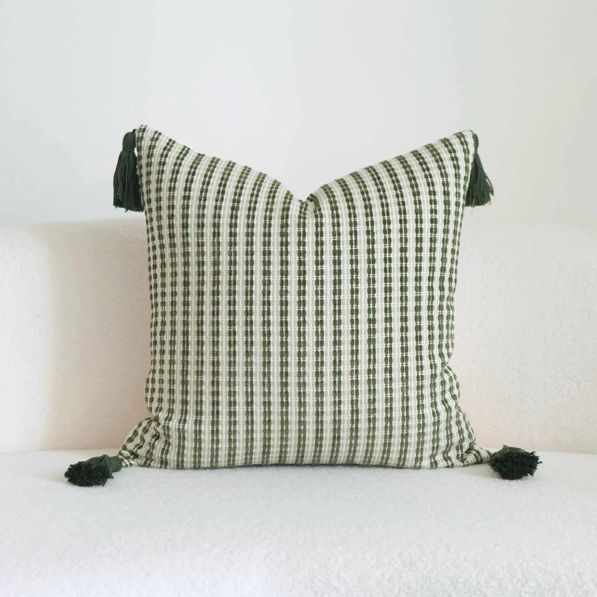 Green cotton and linen hotel sample pillow with tassel details and botanical patterns for display use