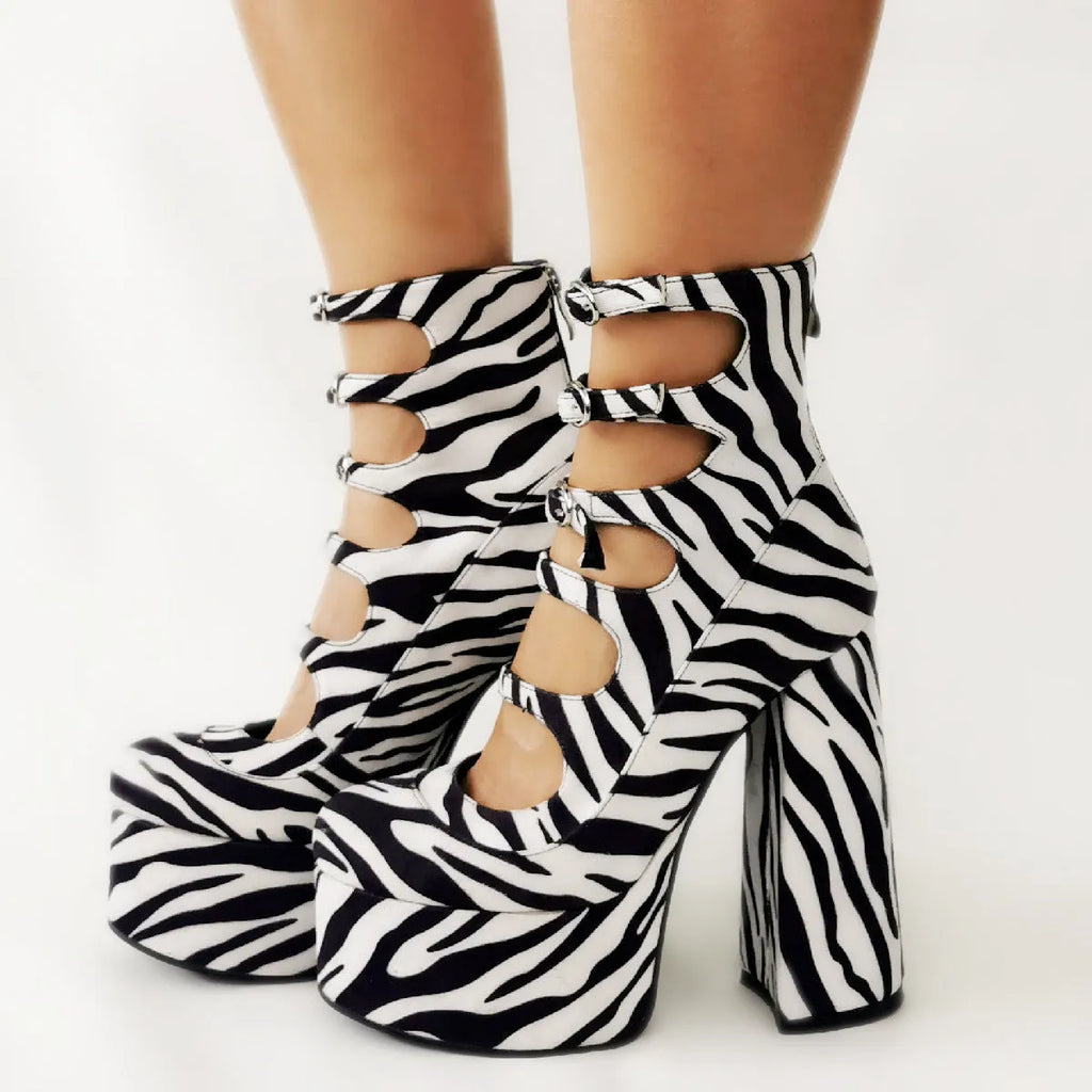 Women's black patent leather platform high heel boots with a thick heel and serpentine ankle buckle.