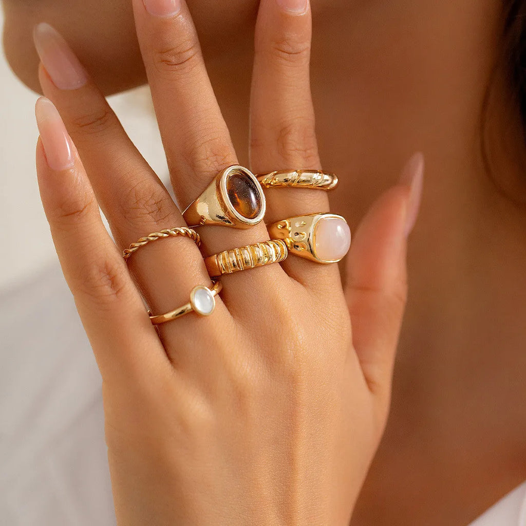 Six geometric alloy rings with irregular designs in light gold colour arranged together