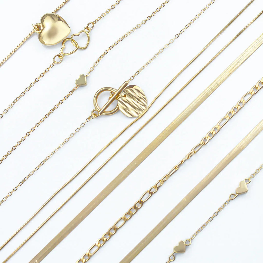 Gold-coloured women's necklace set showing ten pieces with simple alloy pendants on snake bone chains