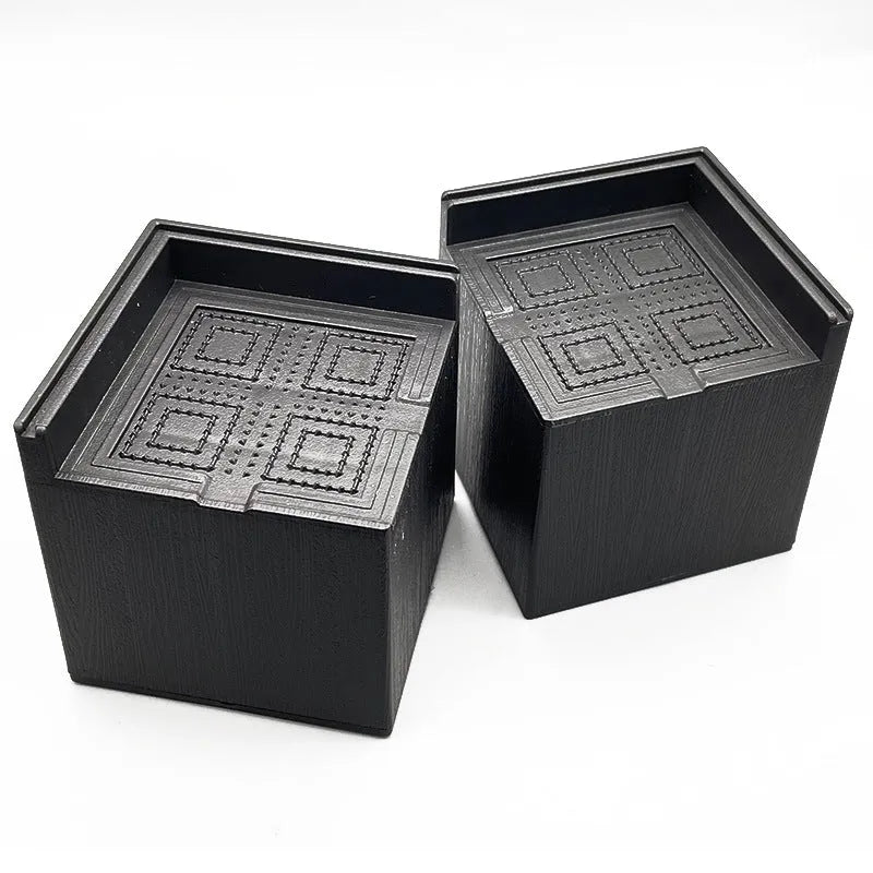 Four black thickened plastic furniture foot mats for height increase and stabilisation