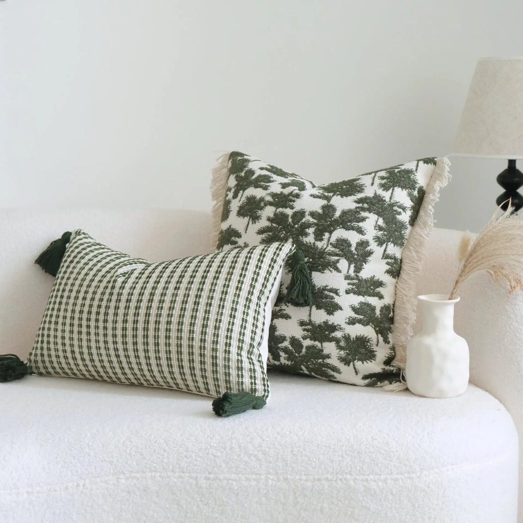 Green cotton and linen hotel sample pillow with tassel details and botanical patterns for display use
