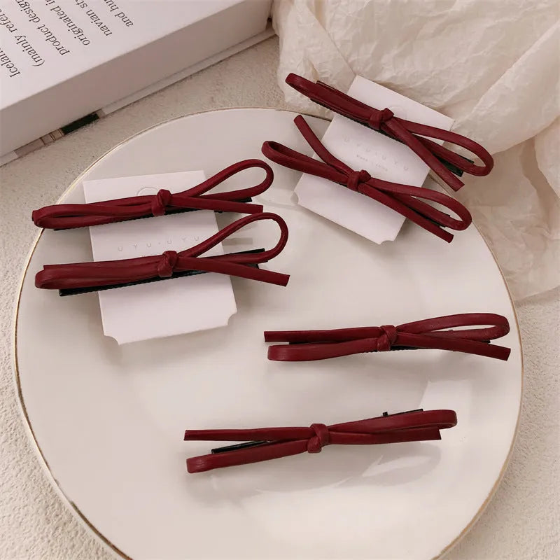 Wine red leather bow hair barrette showing bow design and clip mechanism