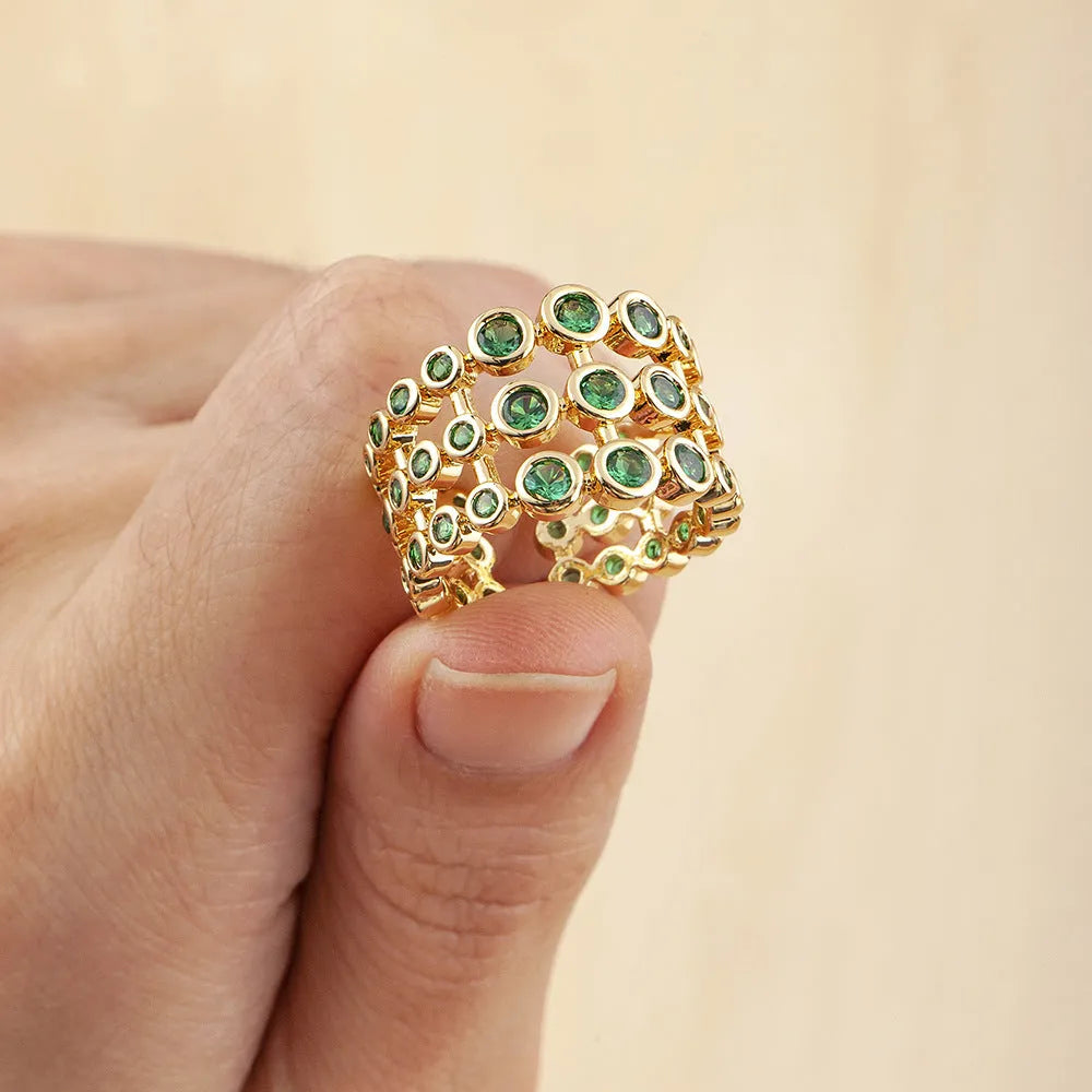 Wide gold-coloured ring with large green zircon stone on copper base with gold plating
