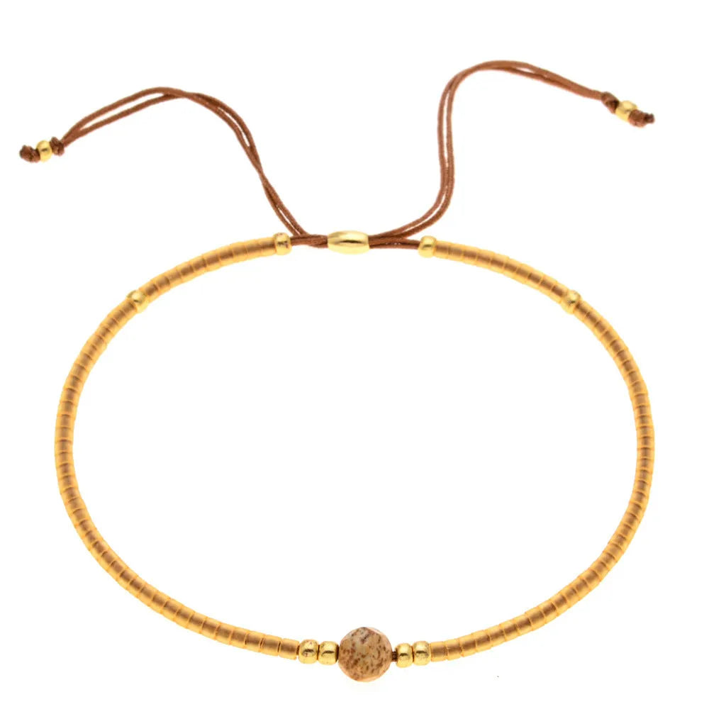 Handmade bohemian bracelet with colourful geometric glass beads on a female wrist.