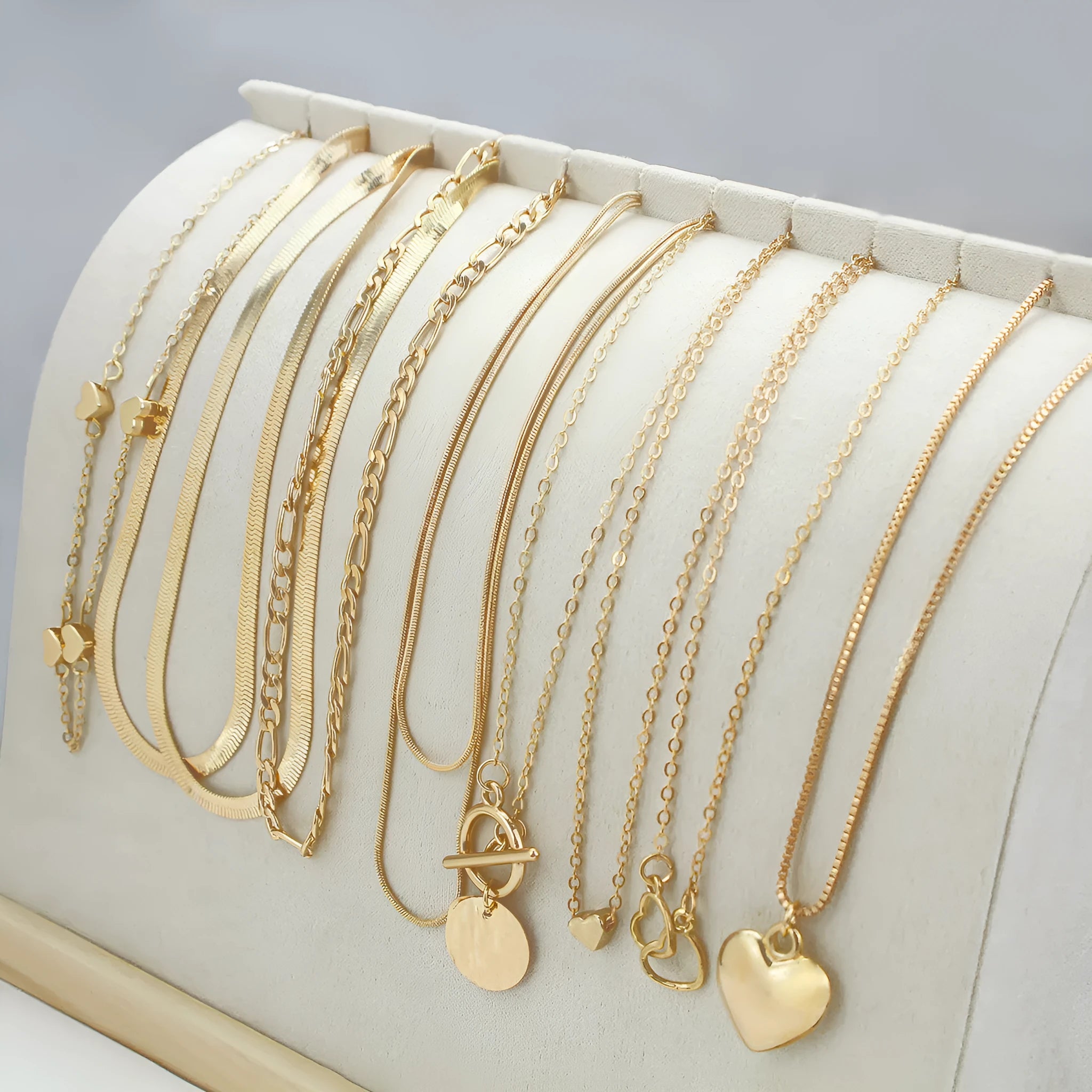 Gold-coloured women's necklace set showing ten pieces with simple alloy pendants on snake bone chains