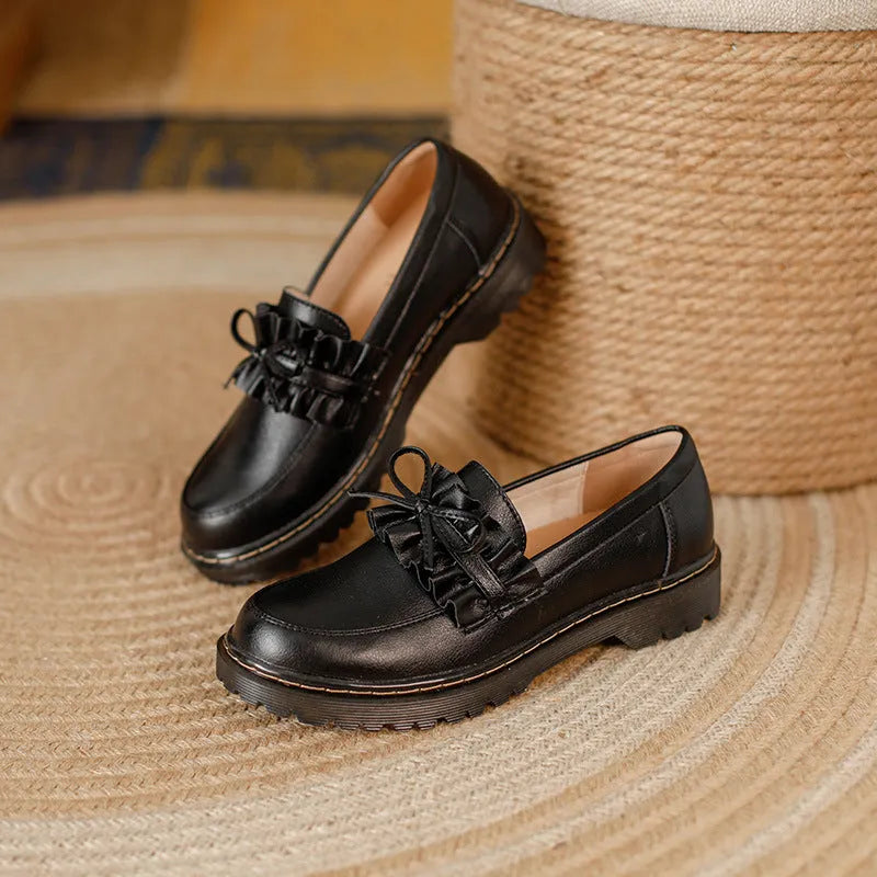Women's black leather shoes with round toe, chunky flat heel, and low-top design on a white background.