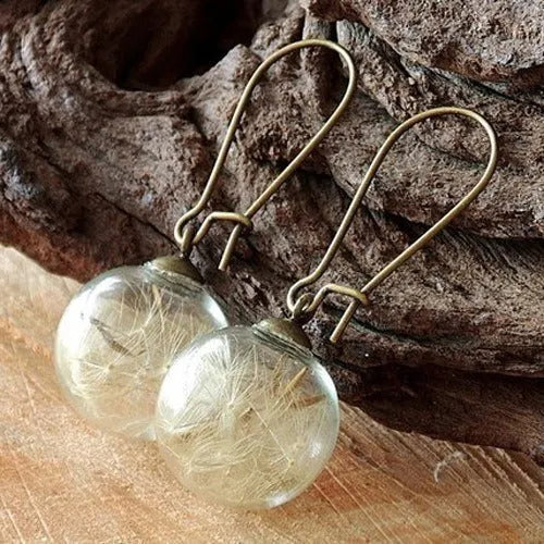Transparent glass ball earrings on a French hook, showing dandelion seed design in silver and bronze finishes.