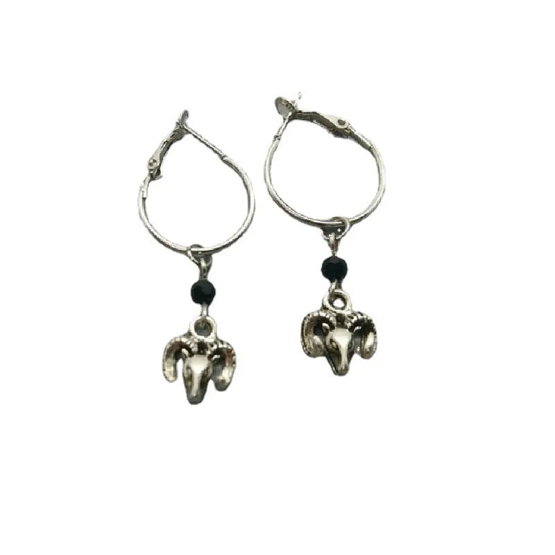 Silver coloured round alloy earrings featuring an engraved Tibetan antelope design.