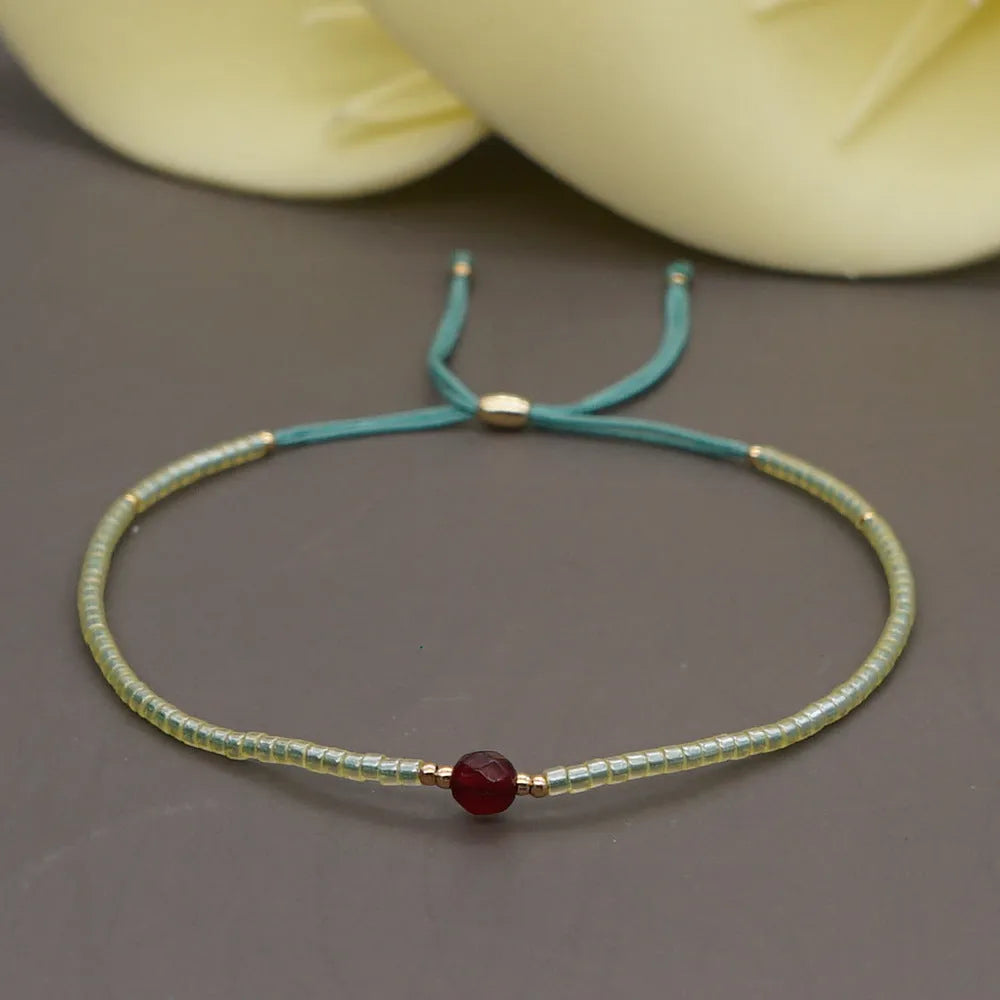 Handmade bohemian bracelet with colourful geometric glass beads on a female wrist.