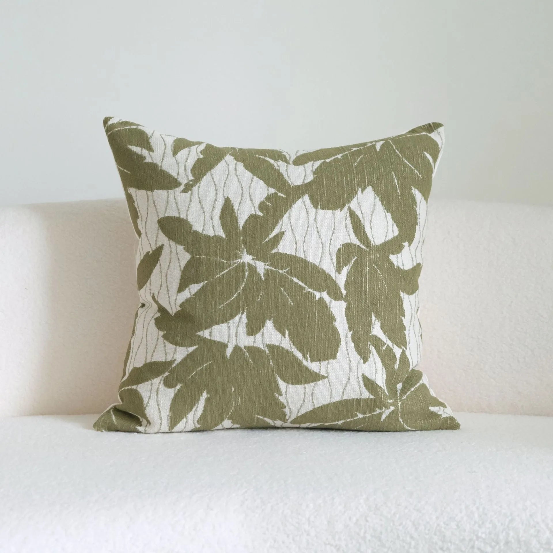 Green cotton and linen hotel sample pillow with tassel details and botanical patterns for display use