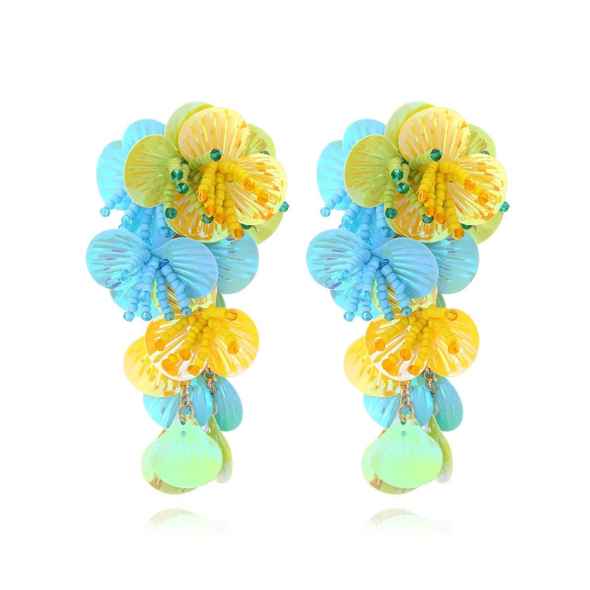 Close-up of handmade colourful bead flower and leaf statement earrings on a white background.