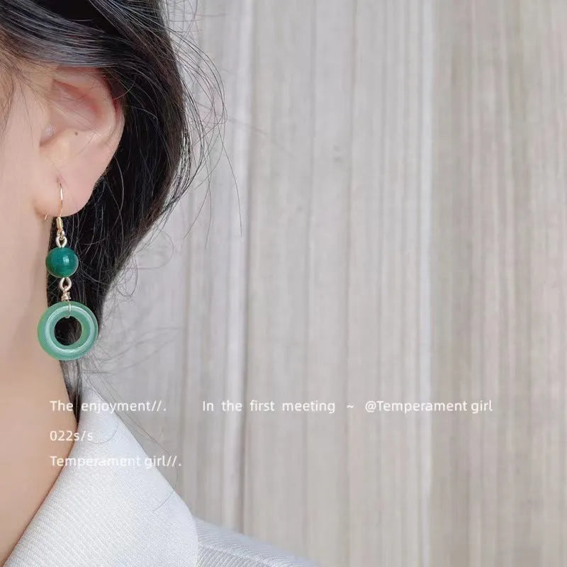 A pair of green geometric peace buckle earrings with a Chinese jade design, made from zinc alloy.