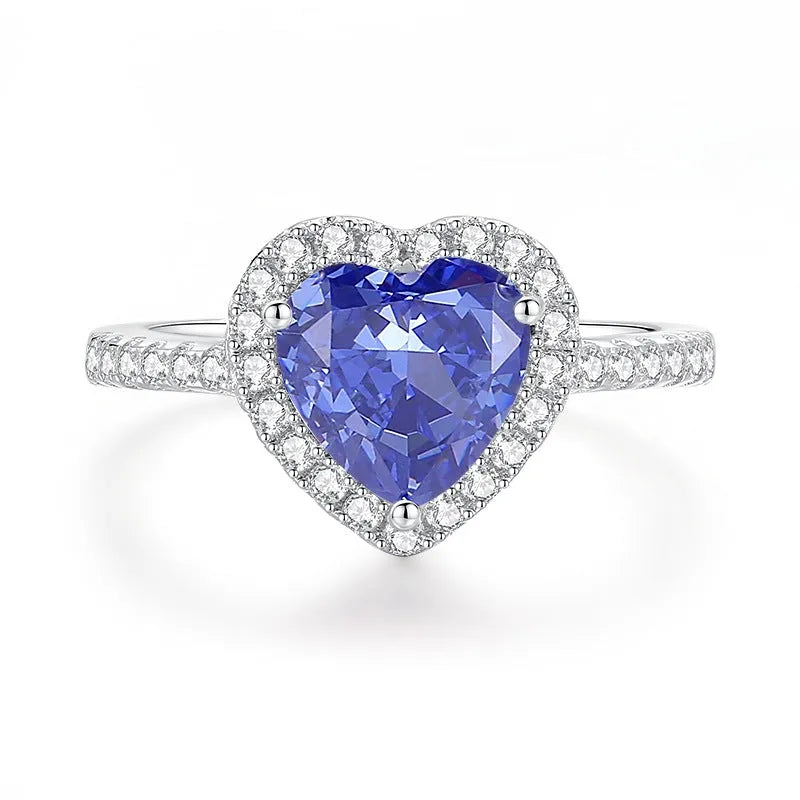 Heart shaped Tanzanite purple zircon ring in sterling silver on a grey background.