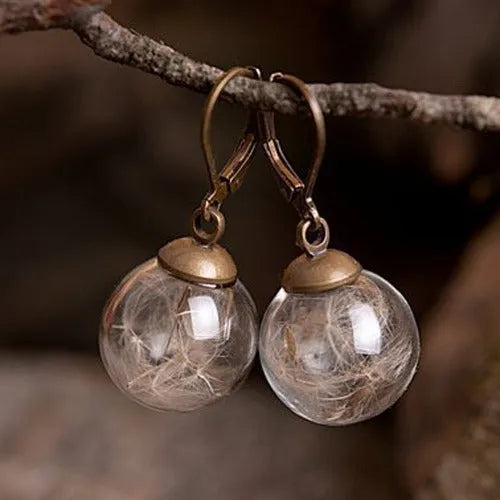 Transparent glass ball earrings on a French hook, showing dandelion seed design in silver and bronze finishes.