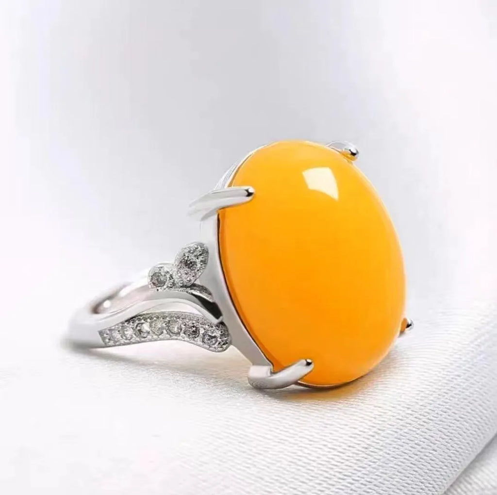Geometric ethnic style adjustable alloy ring in one of five colours on a plain background.