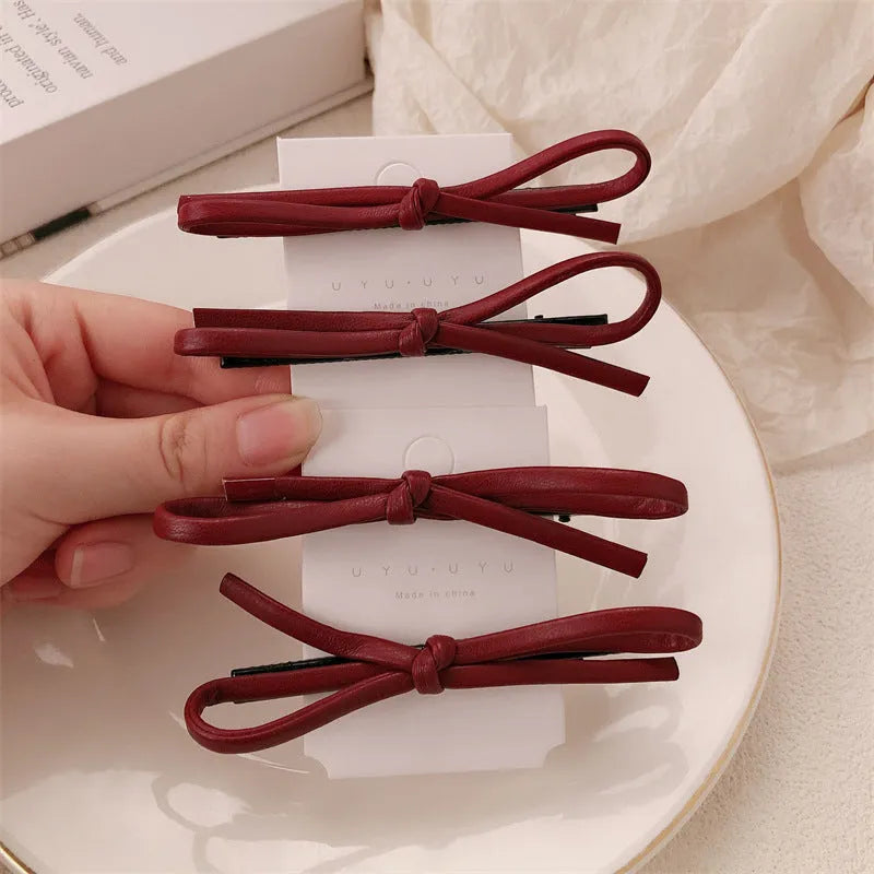 Wine red leather bow hair barrette showing bow design and clip mechanism