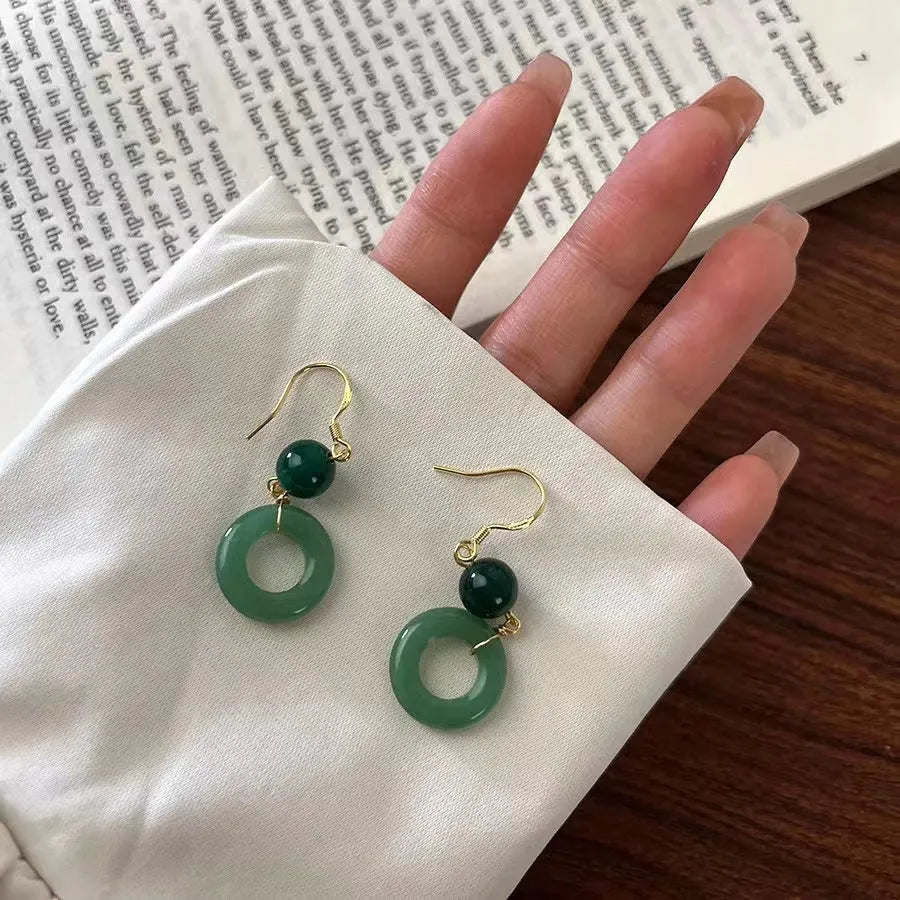A pair of green geometric peace buckle earrings with a Chinese jade design, made from zinc alloy.