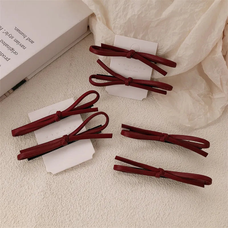Wine red leather bow hair barrette showing bow design and clip mechanism