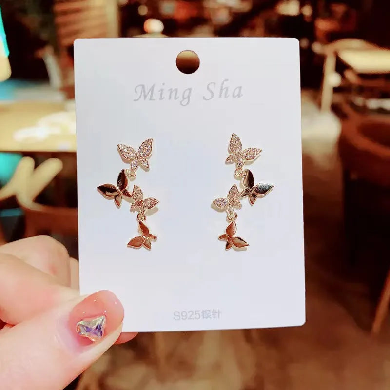 Women's gold colour copper butterfly drop earrings showing four hinged elements