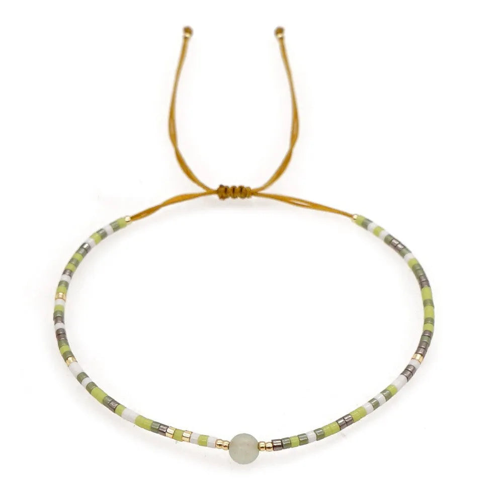 Handmade bohemian bracelet with colourful geometric glass beads on a female wrist.