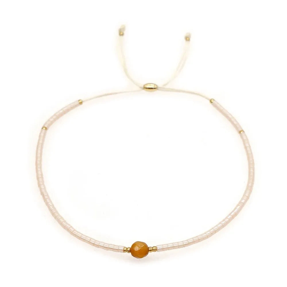 Handmade bohemian bracelet with colourful geometric glass beads on a female wrist.
