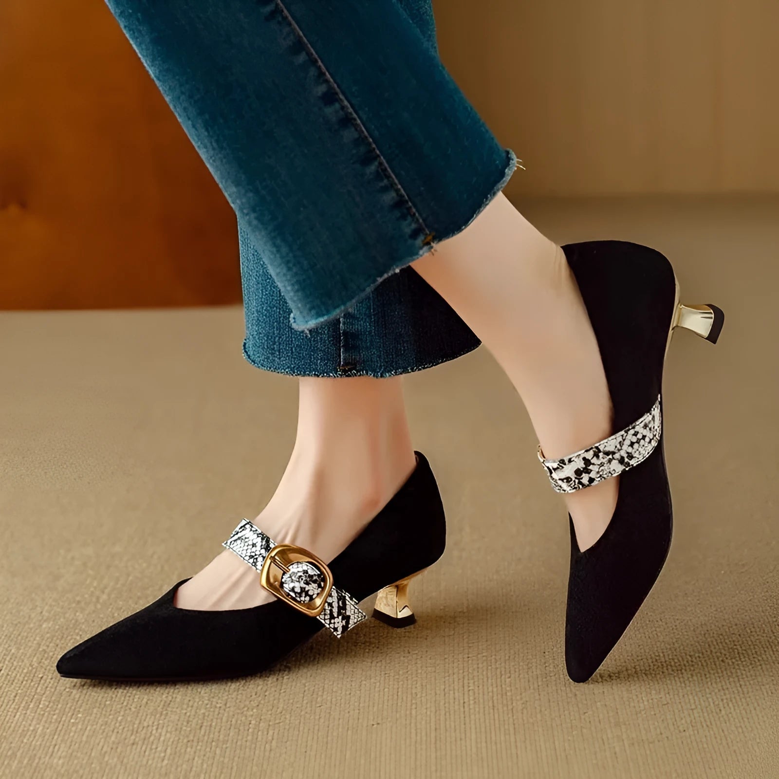 Women's black pointed-toe stiletto heels with a buckle fastening and mid-height heel.
