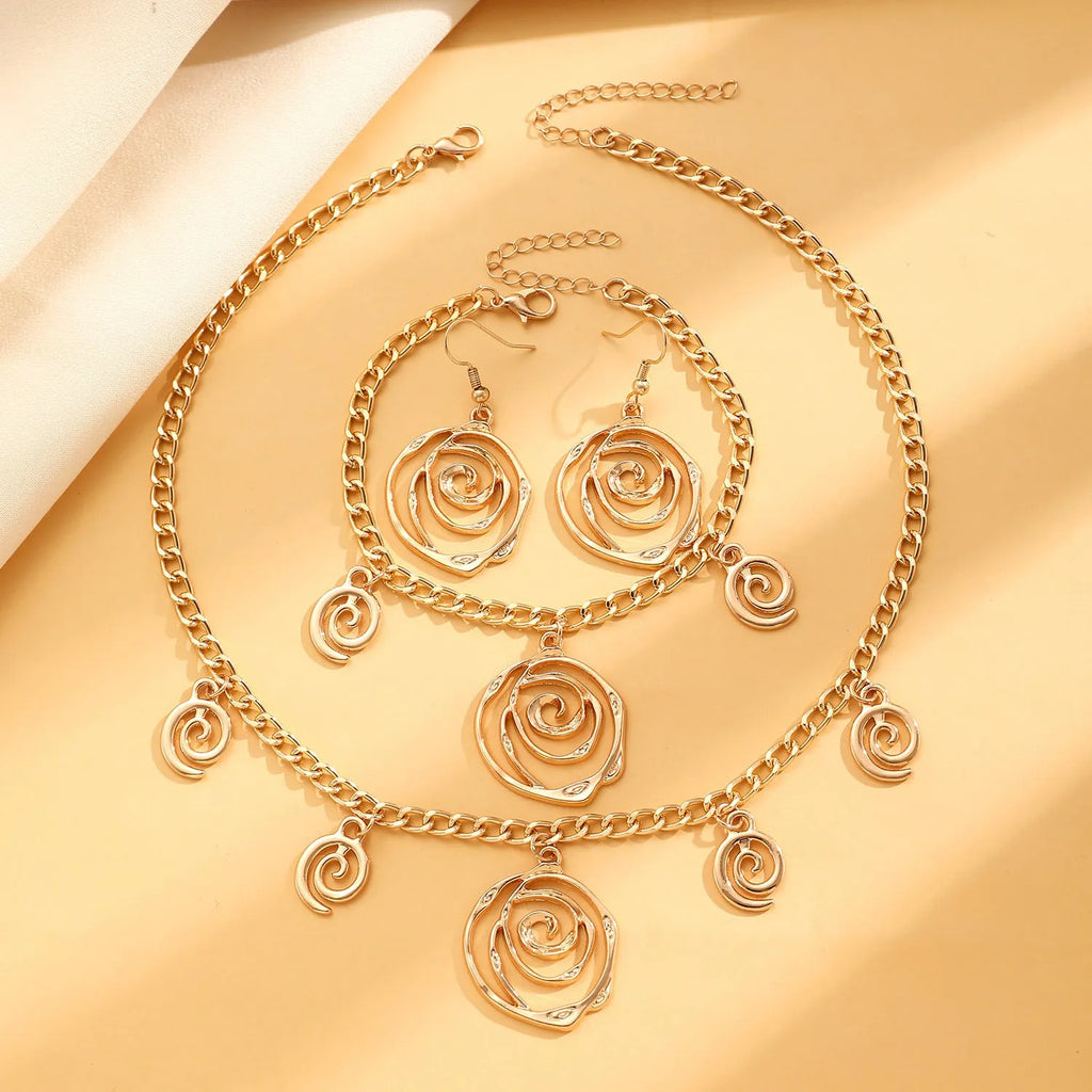 Spiral donut design necklace, bracelet, and ear hook set in gold or silver plating on a dark background.