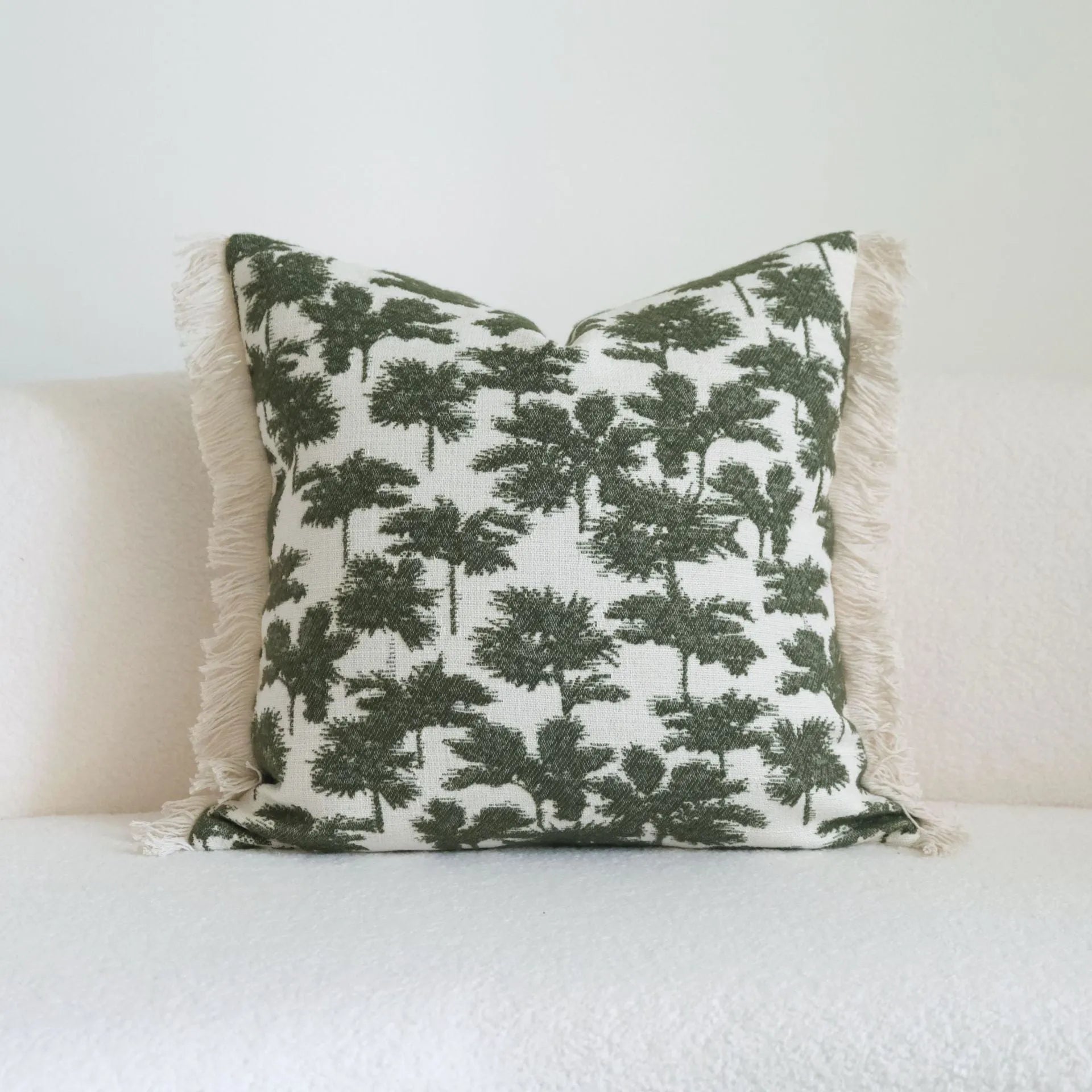 Green cotton and linen hotel sample pillow with tassel details and botanical patterns for display use