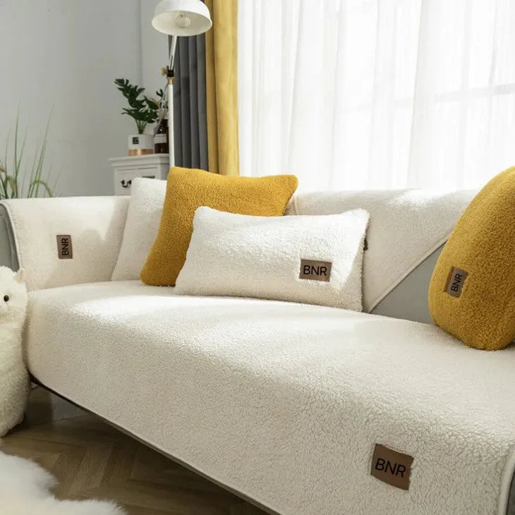 Lambswool sofa cover in solid colour on a sofa, shown in blue, grey, green, white, or yellow.