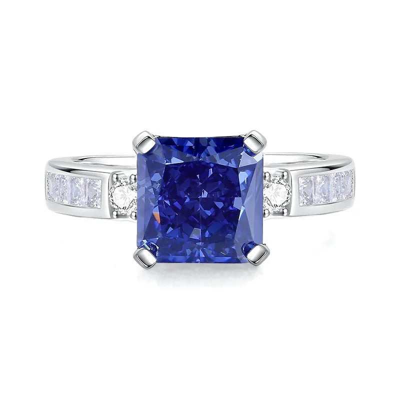 Heart shaped Tanzanite purple zircon ring in sterling silver on a grey background.
