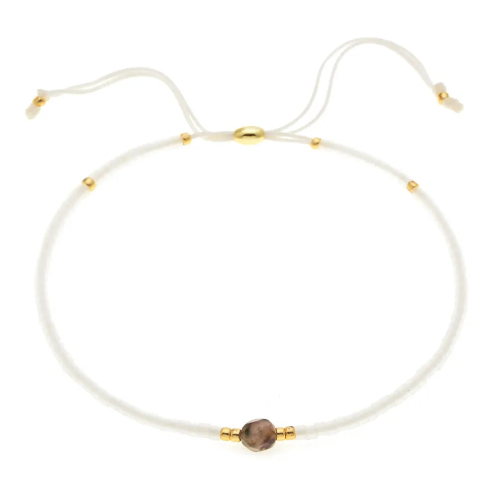 Handmade bohemian bracelet with colourful geometric glass beads on a female wrist.