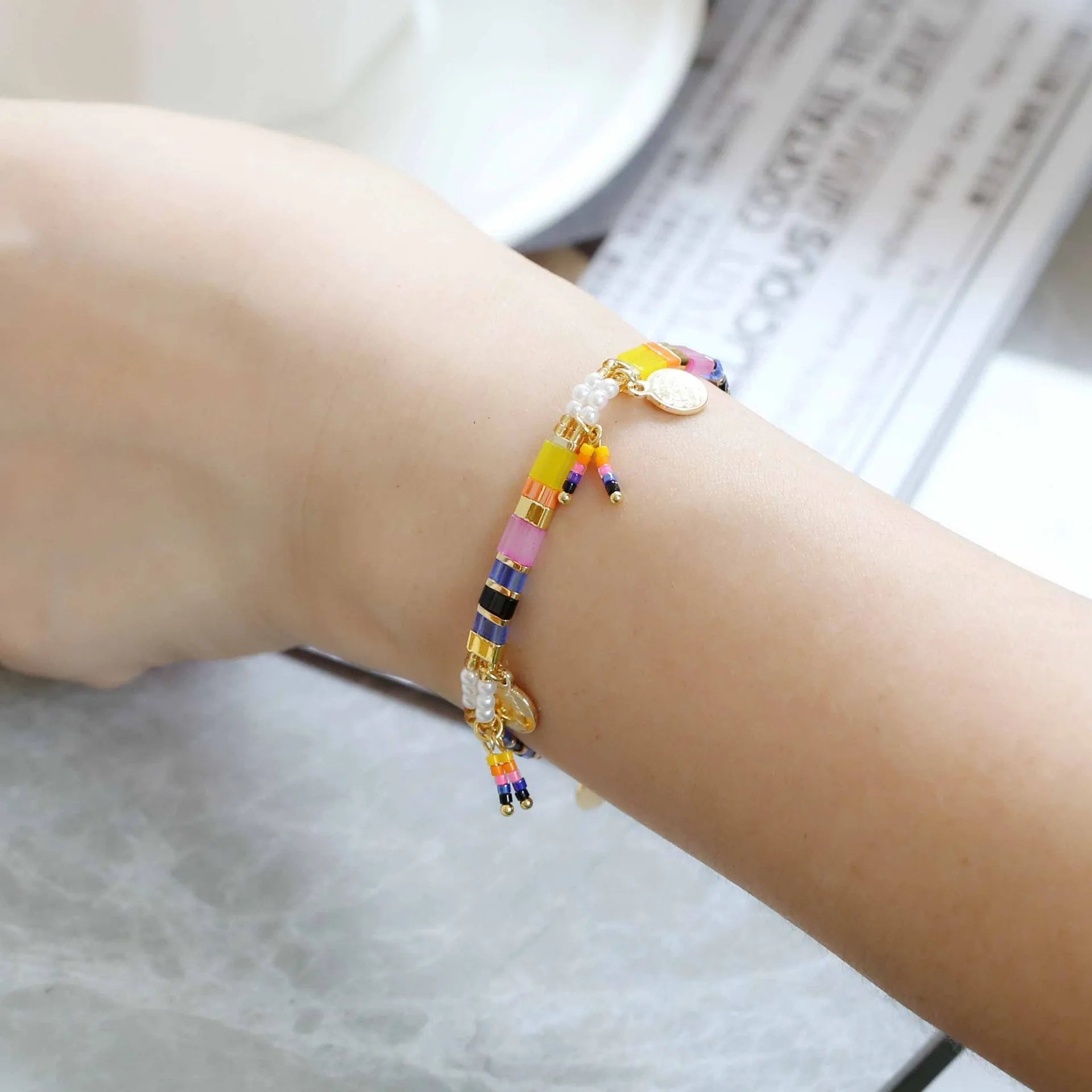 Handcrafted women's bracelet with imitation pearl beads in European style, showing colour variations.